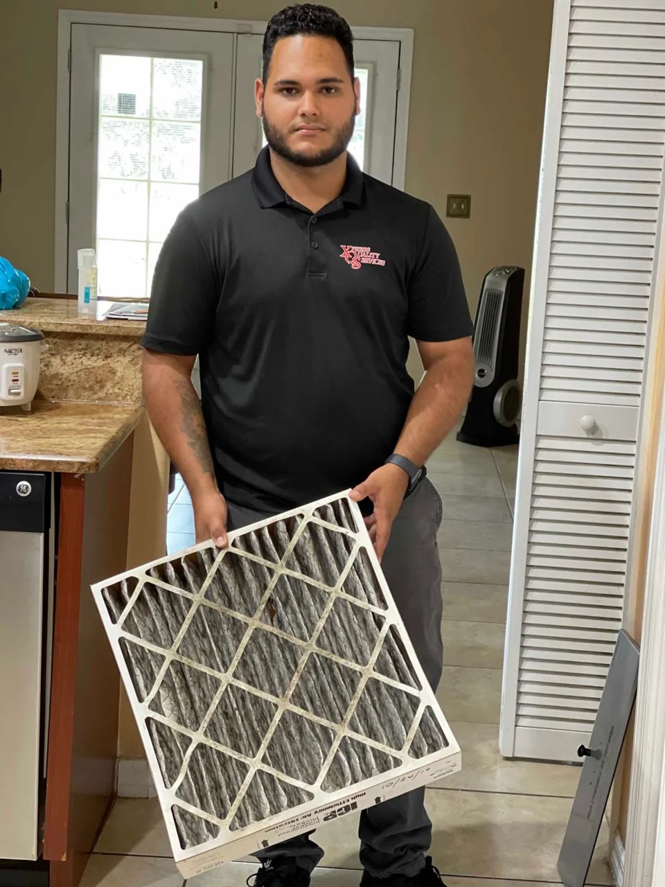 XQS team member holding an HVAC filter