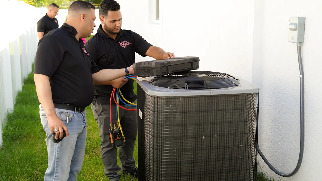 Two XQS technicians servicing an outdoor AC condenser with gauges connected