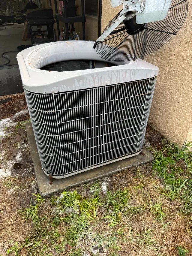 Outdoor AC unit with the top open during service work in Ruskin.